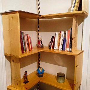 Bibliothèque d'angle en bois avec des livres et objets décoratifs